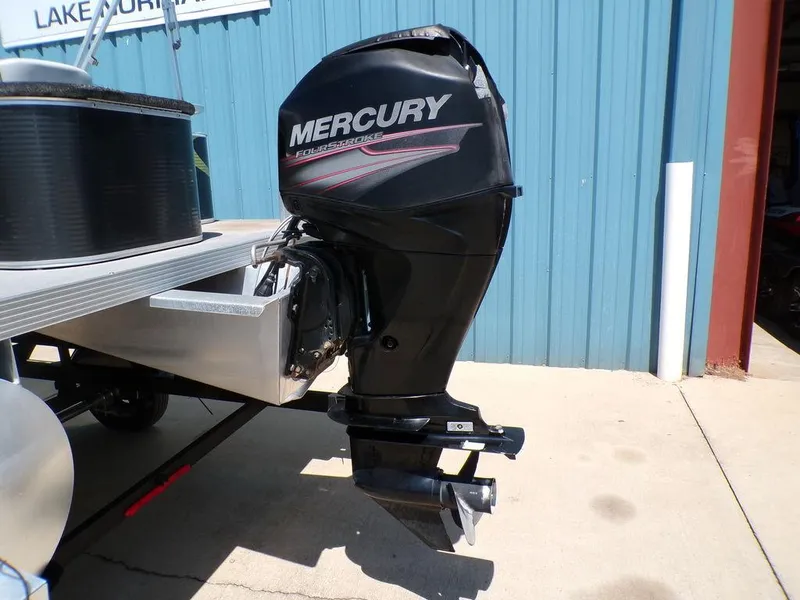 Slide: The Image of 2020 Qwest Edge 816 Cruise with Mercury outboard motor, docked near blue building. - 4