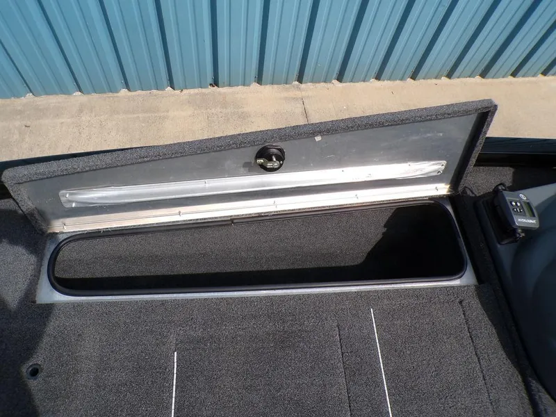 Slide: The Image of 2014 Lowe Stinger ST195 boat storage compartment with open lid, showing interior space. - 14