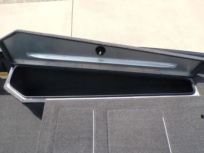 Slide: The Image of 2014 Lowe Stinger ST195 boat storage compartment, open and empty, with carpeted interior. - 16
