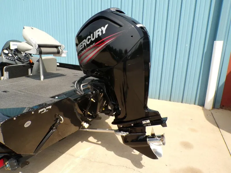 Slide: The Image of 2014 Lowe Stinger ST195 boat with Mercury outboard motor, parked near blue wall. - 7