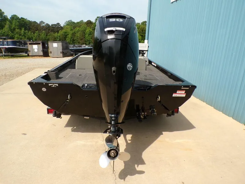 Slide: The Image of 2014 Lowe Stinger ST195 boat with powerful outboard motor, parked on concrete near blue building. - 8