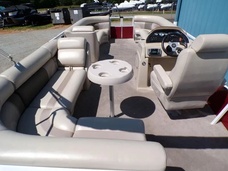 Slide: The Image of 2013 JC Limited 221 Triple pontoon boat interior with beige seating and steering console. - 14
