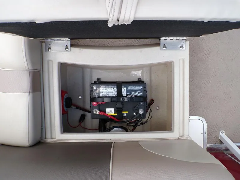 Slide: The Image of Battery compartment of a 2013 JC Limited 221 Triple boat, showing secured battery and wiring. - 24