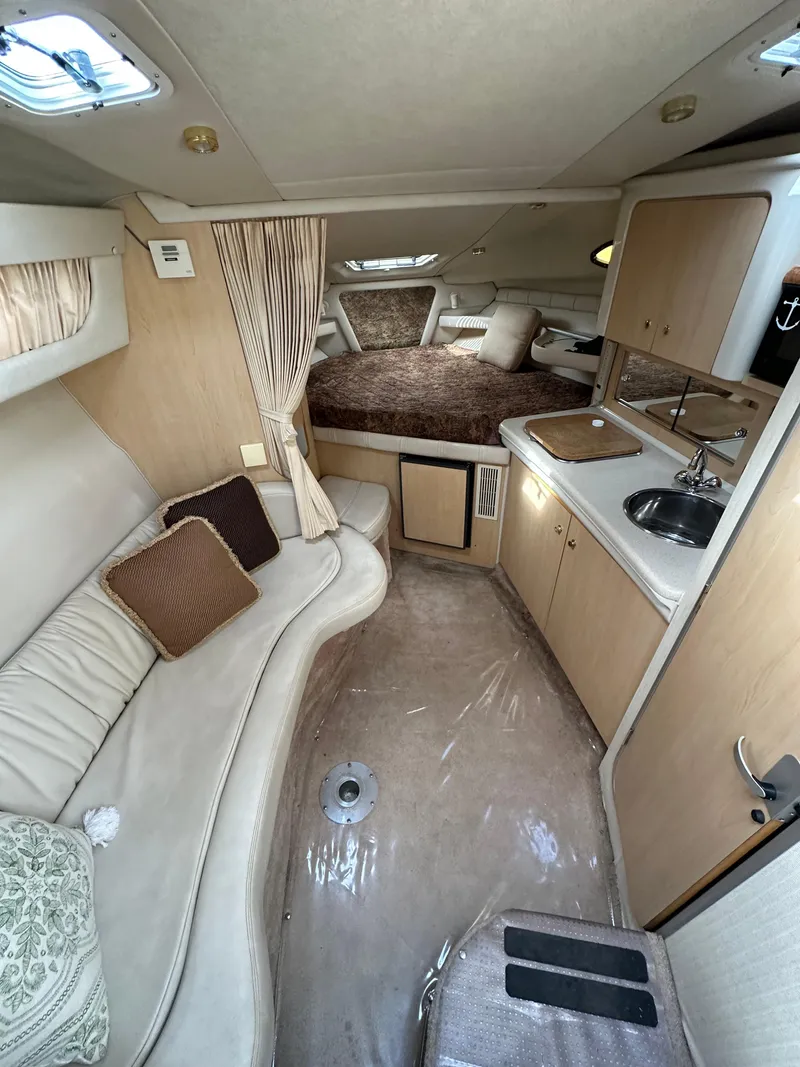 Slide: The Image of 1998 Regal 2760 Commodore cabin interior with seating, kitchenette, and sleeping area. - 13