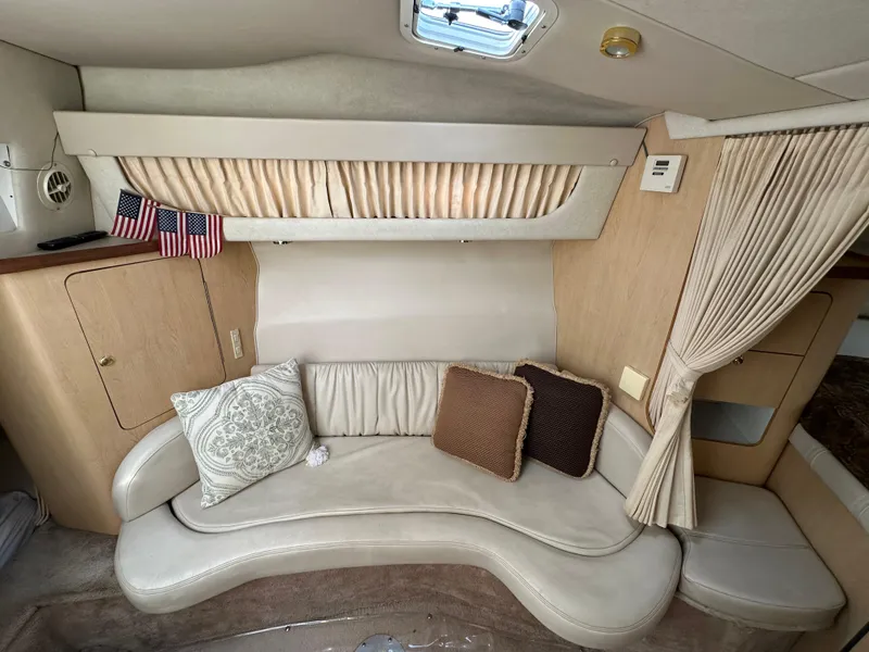 Slide: The Image of 1998 Regal 2760 Commodore cabin interior with curved seating and decorative pillows. - 15