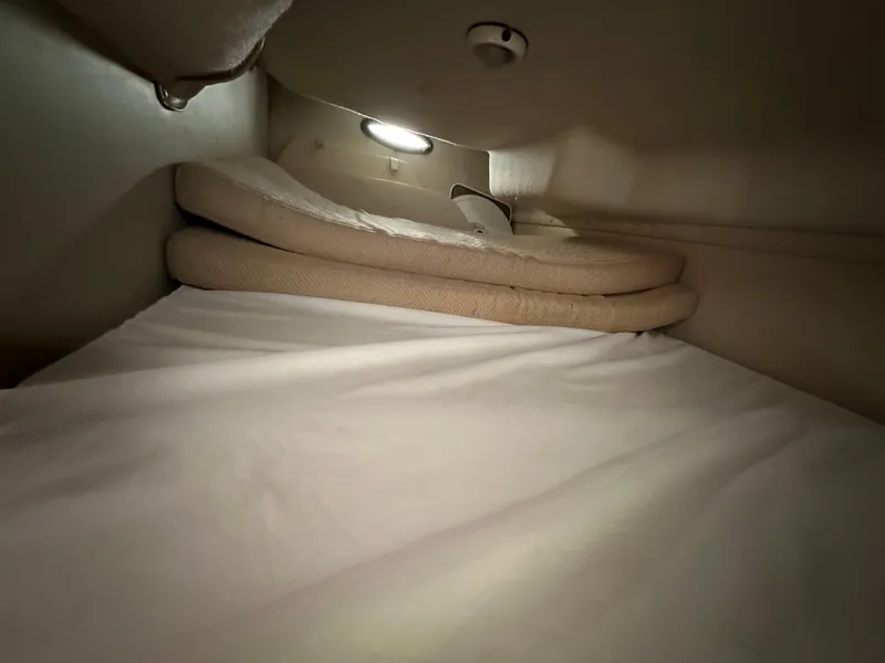 Slide: The Image of 1998 Regal 2760 Commodore cabin interior with stacked cushions and soft lighting. - 17