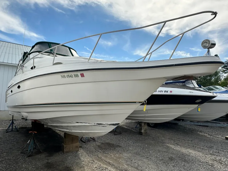 Slide: The Image of 1998 Regal 2760 Commodore boat on stands, white hull, outdoor storage. - 2