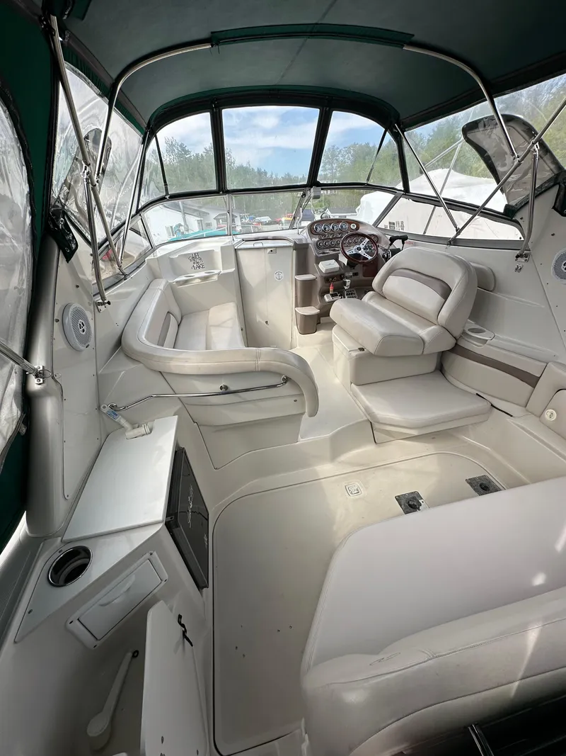 Slide: The Image of 1998 Regal 2760 Commodore boat interior with seating and helm, featuring a green canopy. - 6