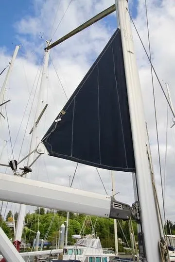 Slide: The Image of 2001 Hunter Passage 420 sailboat mast and sail against a cloudy sky. - 13