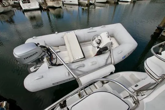 Slide: The Image of Inflatable boat with Honda motor docked near a Hunter Passage 420 yacht. - 16