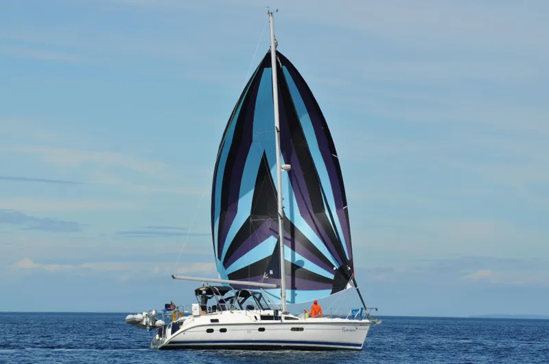 Slide: The Image of 2001 Hunter Passage 420 sailboat with colorful sails on open water. - 2