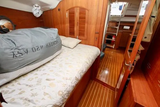 Slide: The Image of 2001 Hunter Passage 420 yacht interior with cozy wooden cabin and bed. - 46