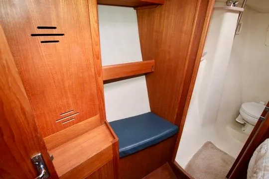 Slide: The Image of Interior of 2001 Hunter Passage 420 sailboat with wooden cabinetry and compact bathroom. - 49