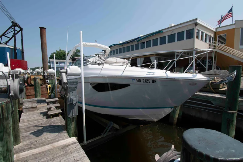 Slide: The Image of 2020 Regal 26 XO boat docked at a marina with buildings in the background. - 1