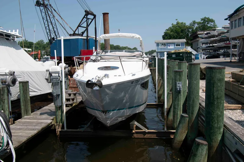 Slide: The Image of 2020 Regal 26 XO boat docked at a marina, surrounded by wooden posts. - 2