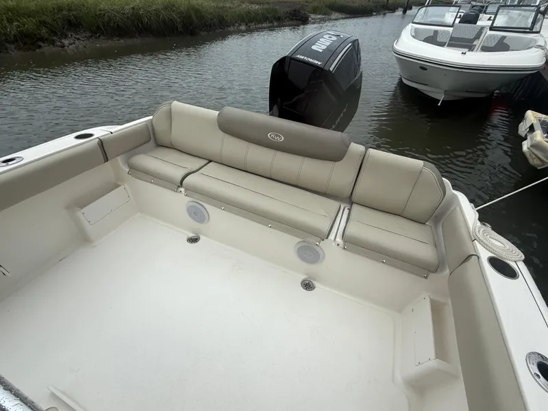 Slide: The Image of 2024 Key West 239 FS boat interior with cushioned seating and outboard motor. - 4