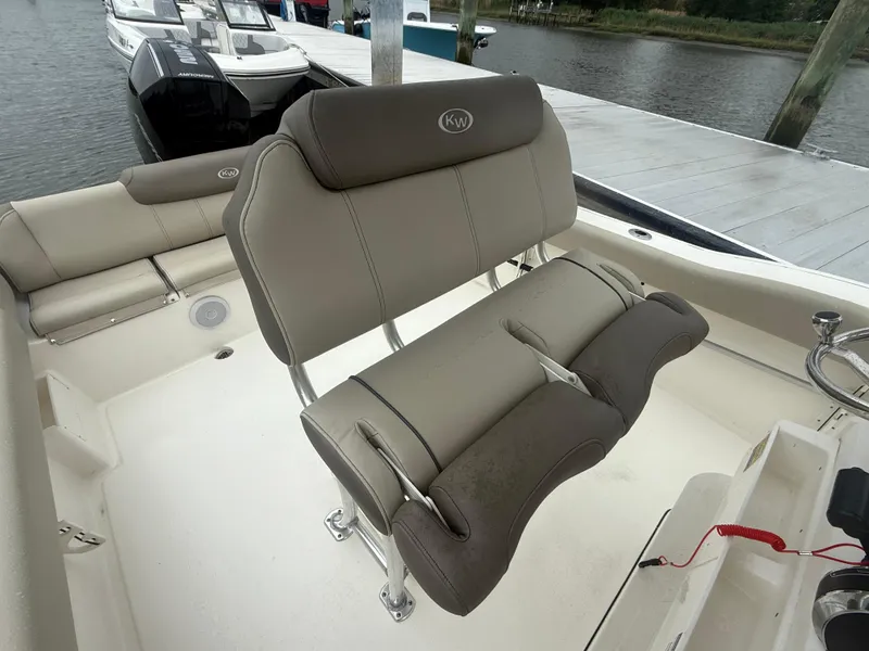Slide: The Image of 2024 Key West 239 FS boat interior with cushioned seating near dock. - 5