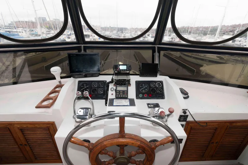 Slide: The Image of 1988 Marine Trader 48 Trawler helm with navigation equipment and wooden steering wheel. - 11