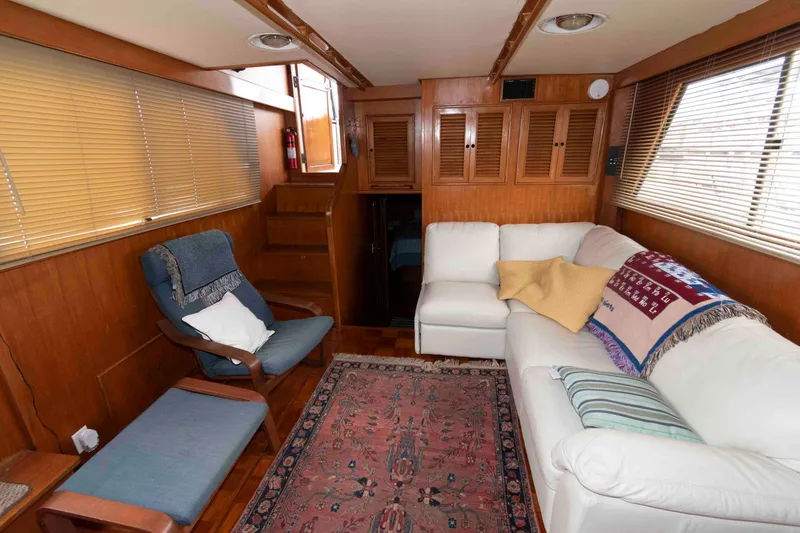 Slide: The Image of Interior of 1988 Marine Trader 48 Trawler with cozy seating and wooden accents. - 14