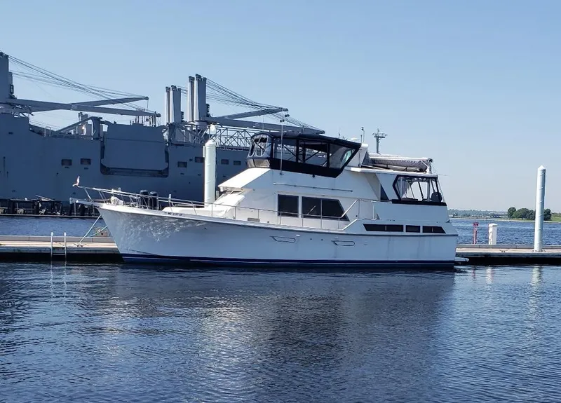 Slide: The Image of 1988 Marine Trader 48 Trawler docked at a marina, with large ship in the background. - 2