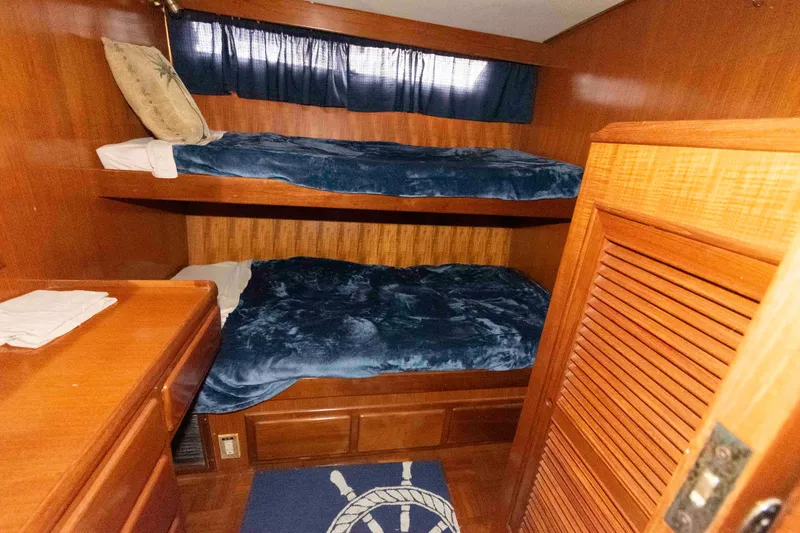 Slide: The Image of Cozy cabin with bunk beds in 1988 Marine Trader 48 Trawler, featuring wooden interior and nautical decor. - 22