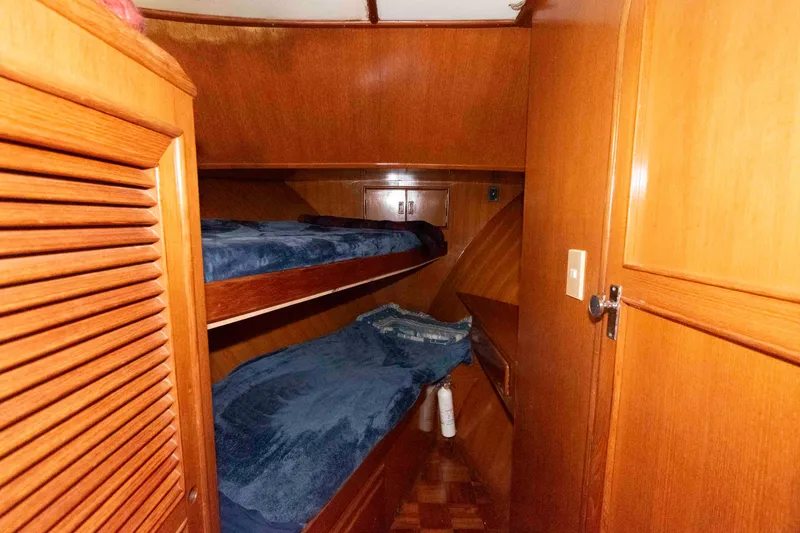 Slide: The Image of 1988 Marine Trader 48 Trawler cabin with wooden interior and bunk beds. - 23
