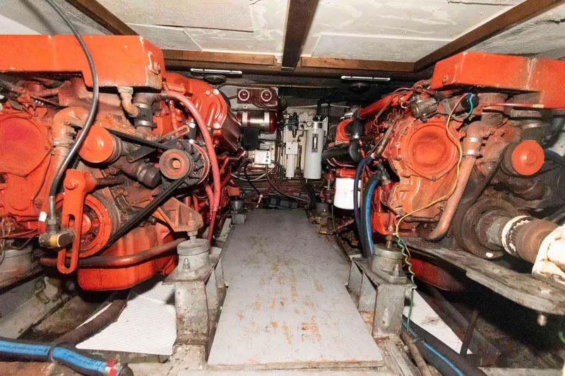 Slide: The Image of Engine room of 1988 Marine Trader 48 Trawler with dual engines and mechanical components. - 25