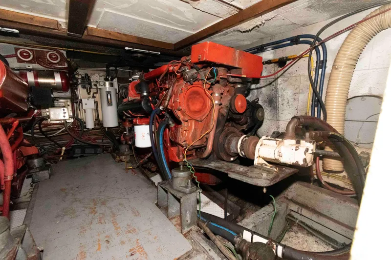 Slide: The Image of Engine room of a 1988 Marine Trader 48 Trawler, showcasing mechanical components and wiring. - 26