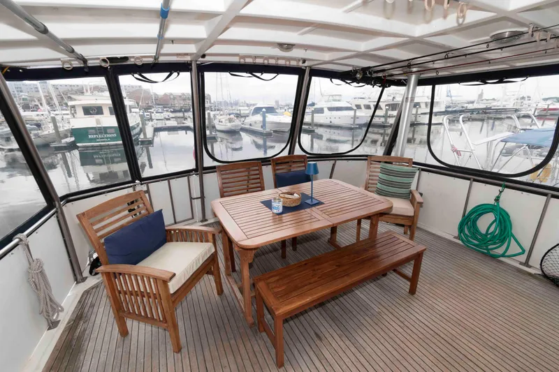 Slide: The Image of Marine Trader 48 Trawler 1988 deck with wooden furniture and marina view. - 3