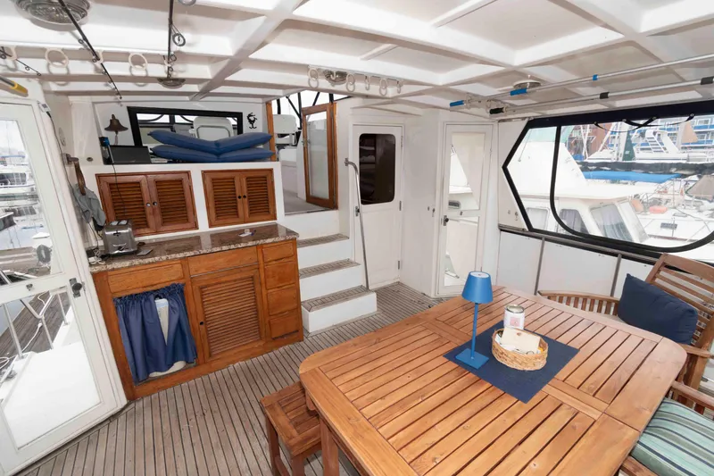 Slide: The Image of 1988 Marine Trader 48 Trawler interior with wooden dining set and kitchenette. - 5