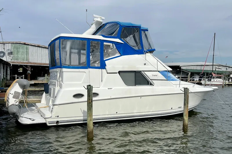 The Image of 1997 Silverton 372 Motor Yacht docked at marina with blue canopy. - 0