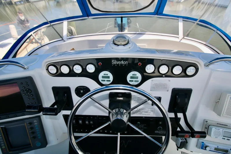 Slide: The Image of 1997 Silverton 372 Motor Yacht dashboard with steering wheel and navigation instruments. - 12