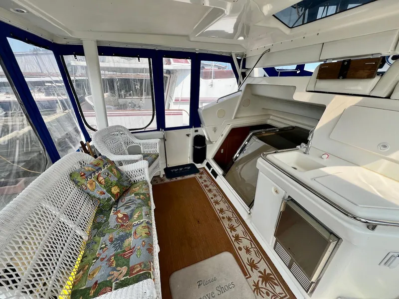 Slide: The Image of 1997 Silverton 372 Motor Yacht interior with wicker seating and kitchenette. - 20