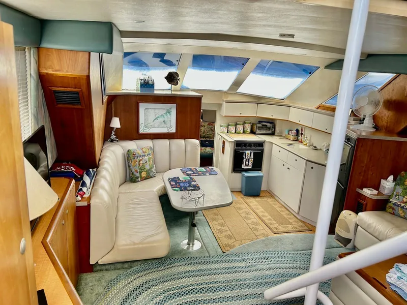 Slide: The Image of Interior of a 1997 Silverton 372 Motor Yacht with cozy seating and kitchen area. - 21
