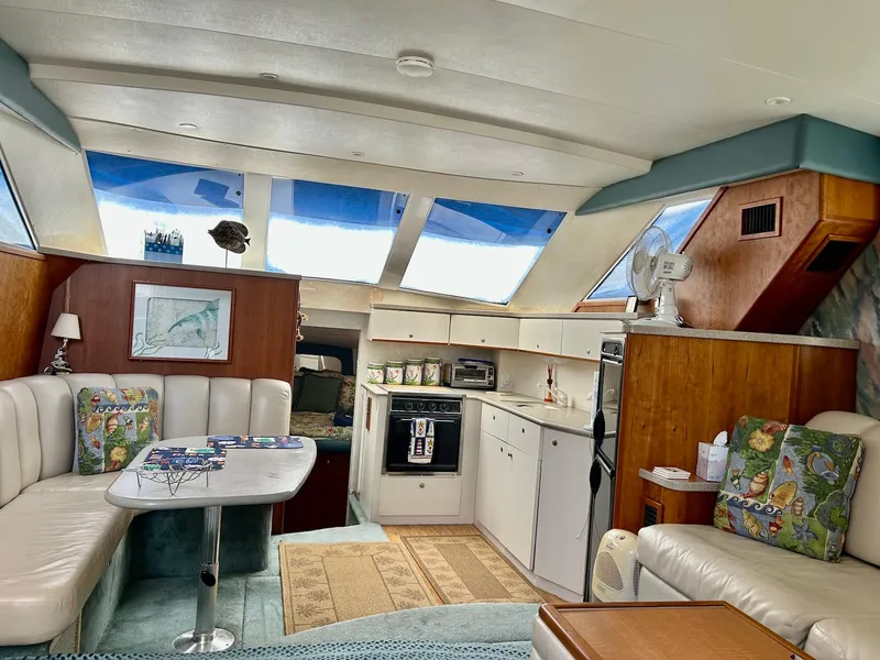 Slide: The Image of Interior of 1997 Silverton 372 Motor Yacht with cozy seating and kitchen area. - 24