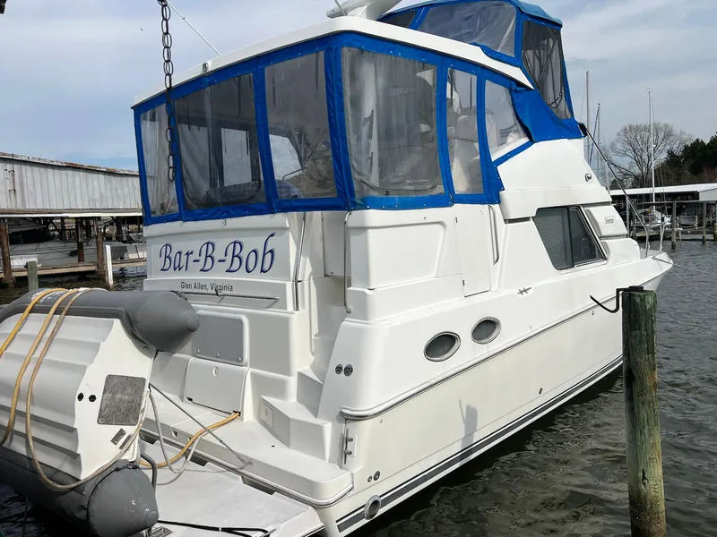 Slide: The Image of 1997 Silverton 372 Motor Yacht docked with blue canopy and inflatable boat. - 4