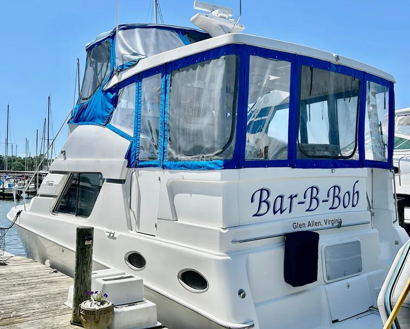 Slide: The Image of 1997 Silverton 372 Motor Yacht docked, featuring blue trim and named "Bar-B-Bob." - 5