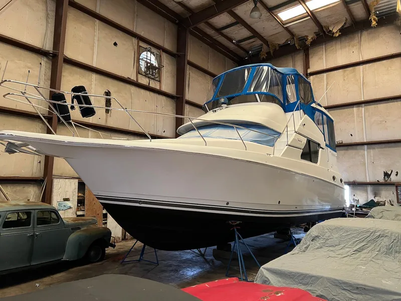 Slide: The Image of 1997 Silverton 372 Motor Yacht in storage, featuring a sleek design and blue canopy. - 7