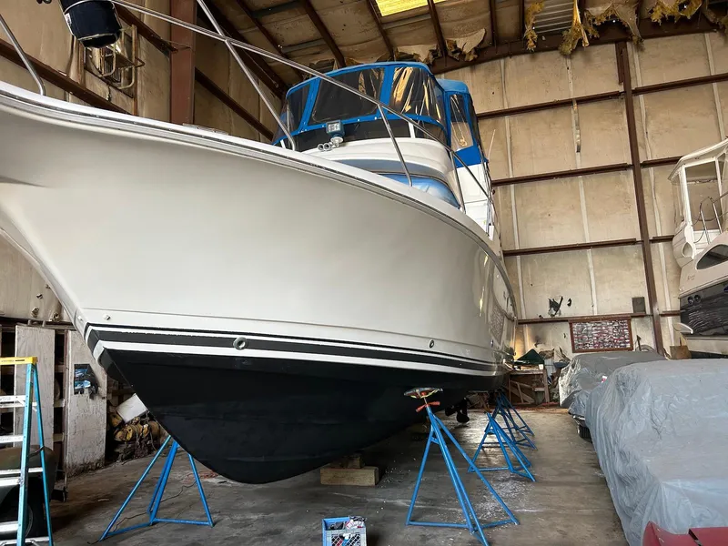 Slide: The Image of 1997 Silverton 372 Motor Yacht in storage, elevated on stands in a warehouse. - 8