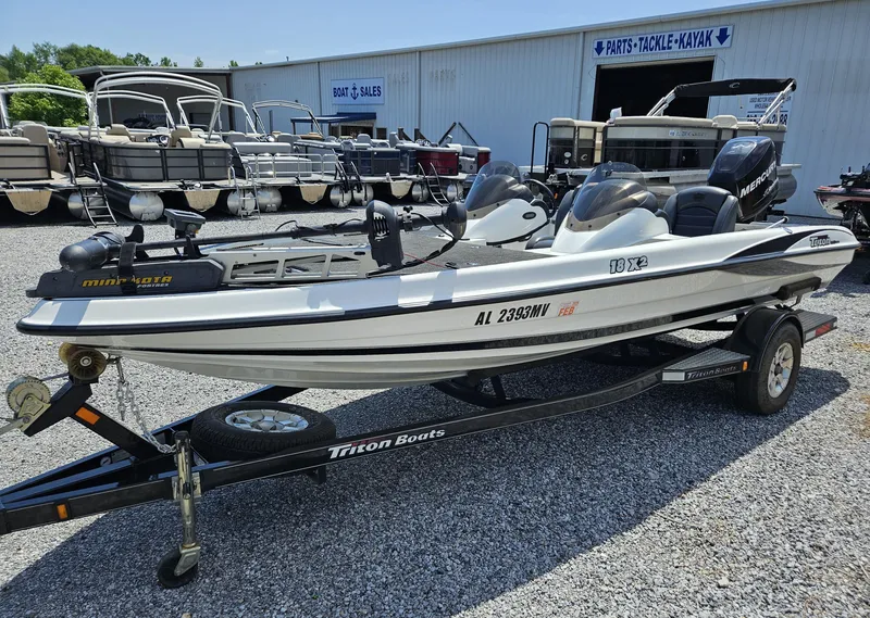 Slide: The Image of 2008 Triton 18X2 boat on trailer at dealership, surrounded by other boats. - 1