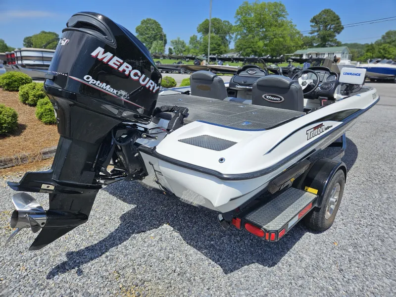 Slide: The Image of 2008 Triton 18X2 boat with Mercury OptiMax engine on a trailer, parked outdoors. - 10