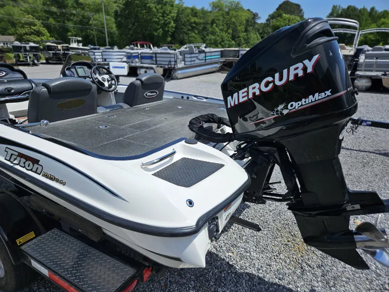 Slide: The Image of 2008 Triton 18X2 boat with Mercury OptiMax engine, parked on gravel lot. - 6