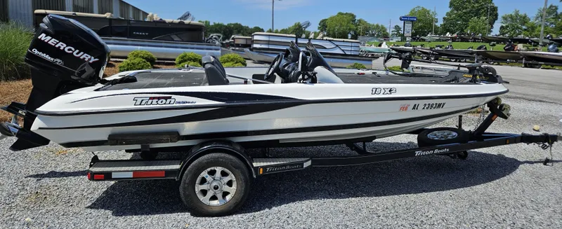 Slide: The Image of 2008 Triton 18X2 boat with Mercury engine on trailer, parked outdoors. - 9