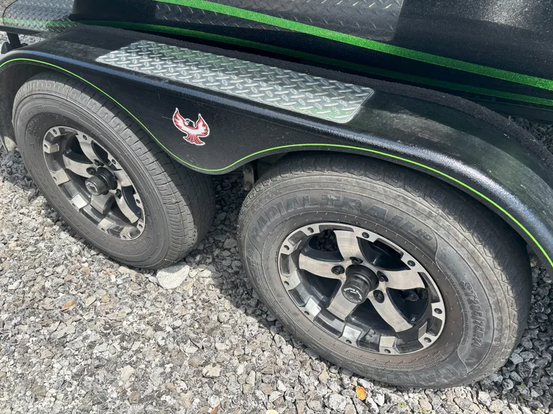 Slide: The Image of 2019 Phoenix 920 PRO XP trailer wheels on gravel, featuring black rims and green accents. - 10