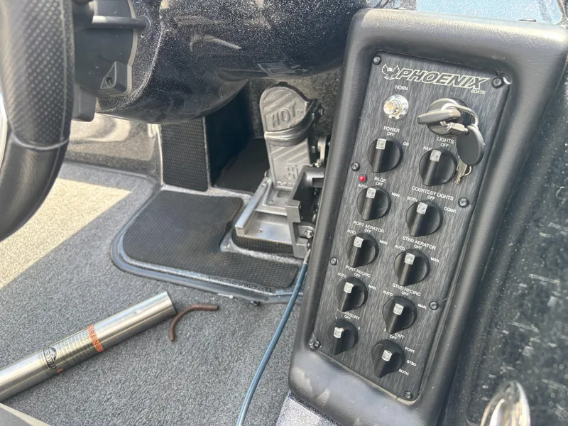 Slide: The Image of Control panel of a 2019 Phoenix 920 PRO XP boat with switches and steering wheel. - 7