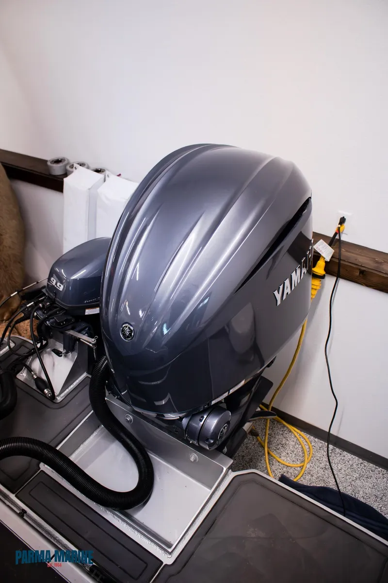 Slide: The Image of 2023 Extreme Boats 745 Game King with Yamaha outboard motor in a workshop setting. - 13