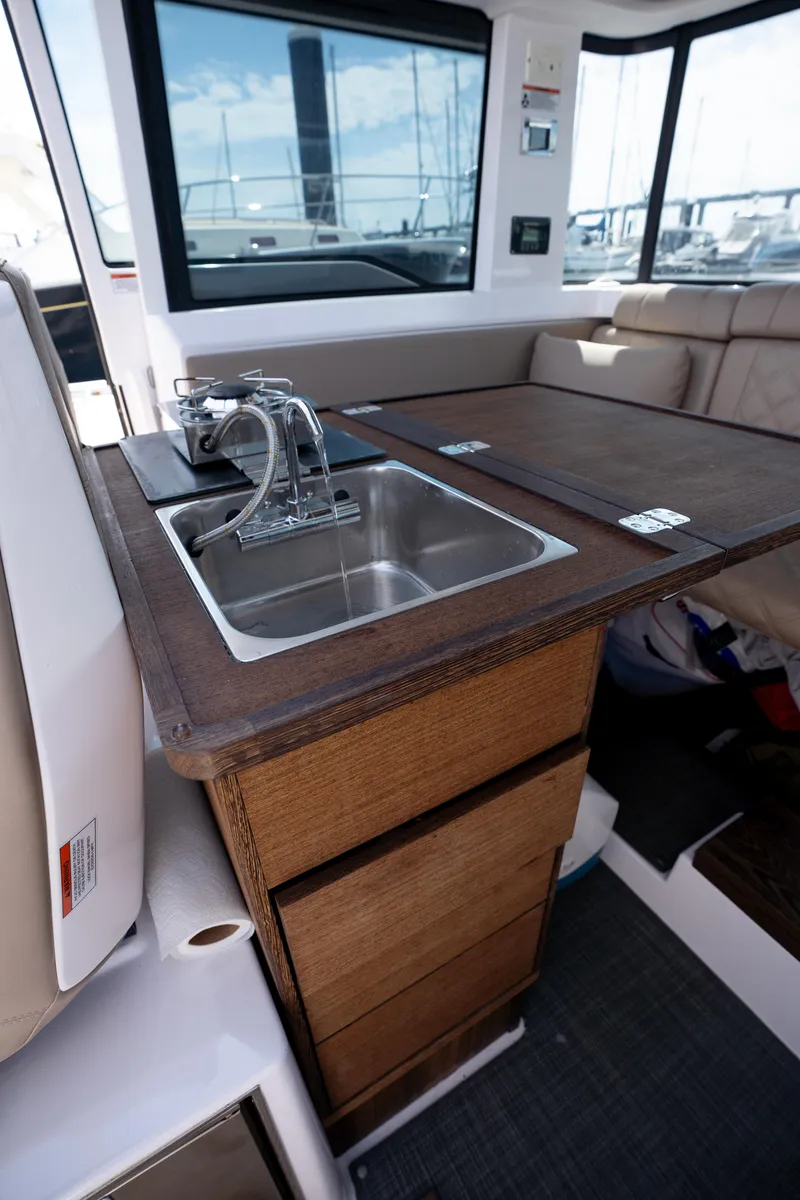 Slide: The Image of 2022 Axopar XC Aft Cabin interior with wooden kitchenette and sink. - 13