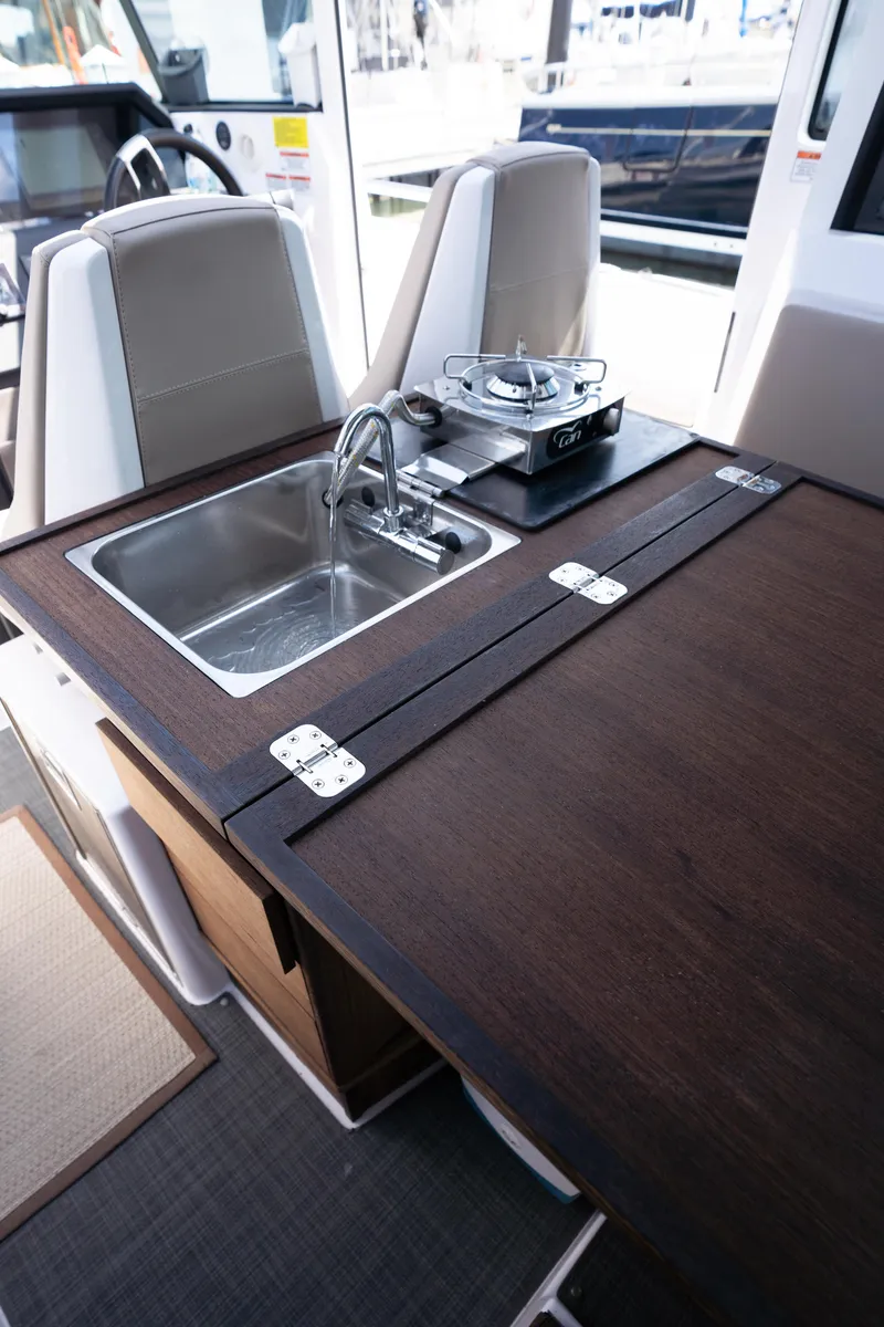 Slide: The Image of 2022 Axopar XC Aft Cabin interior with sink and stove in compact kitchen area. - 14