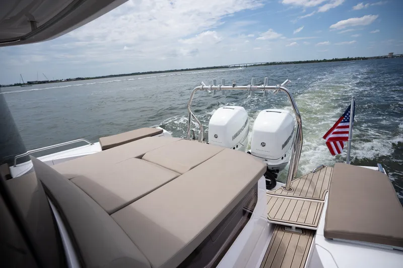 Slide: The Image of 2022 Axopar XC Aft Cabin boat with twin engines and American flag on open water. - 20