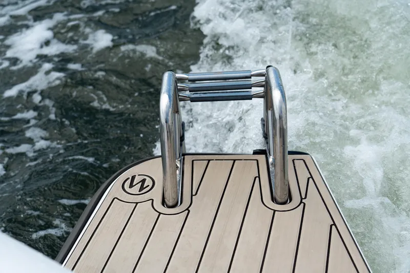 Slide: The Image of Stainless steel ladder on 2022 Axopar XC Aft Cabin boat, with water in the background. - 23